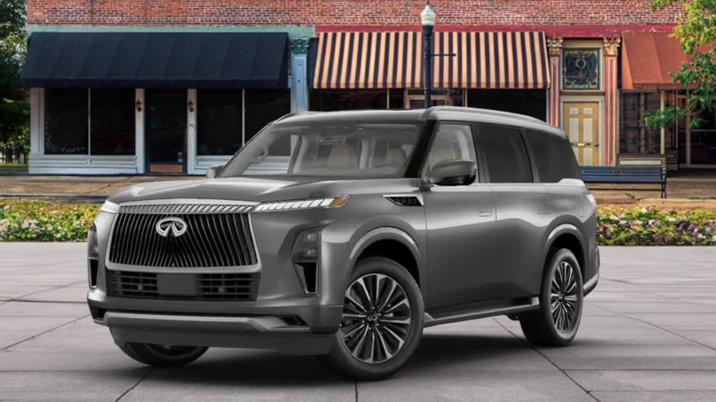 2027 INFINITI QX80 LUXE in graphite gray with larger chrome-trimmed grille and split-spoke alloys, front three-quarter view