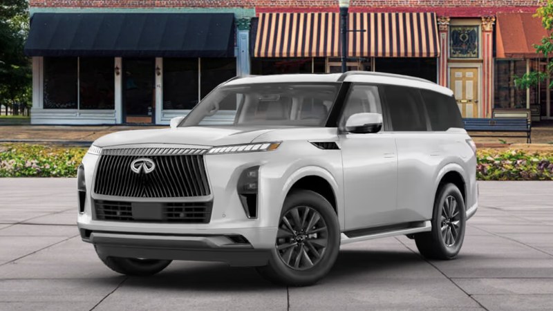 2027 INFINITI QX80 PURE in Moonbow White with chrome grille, front three-quarter view on a city street