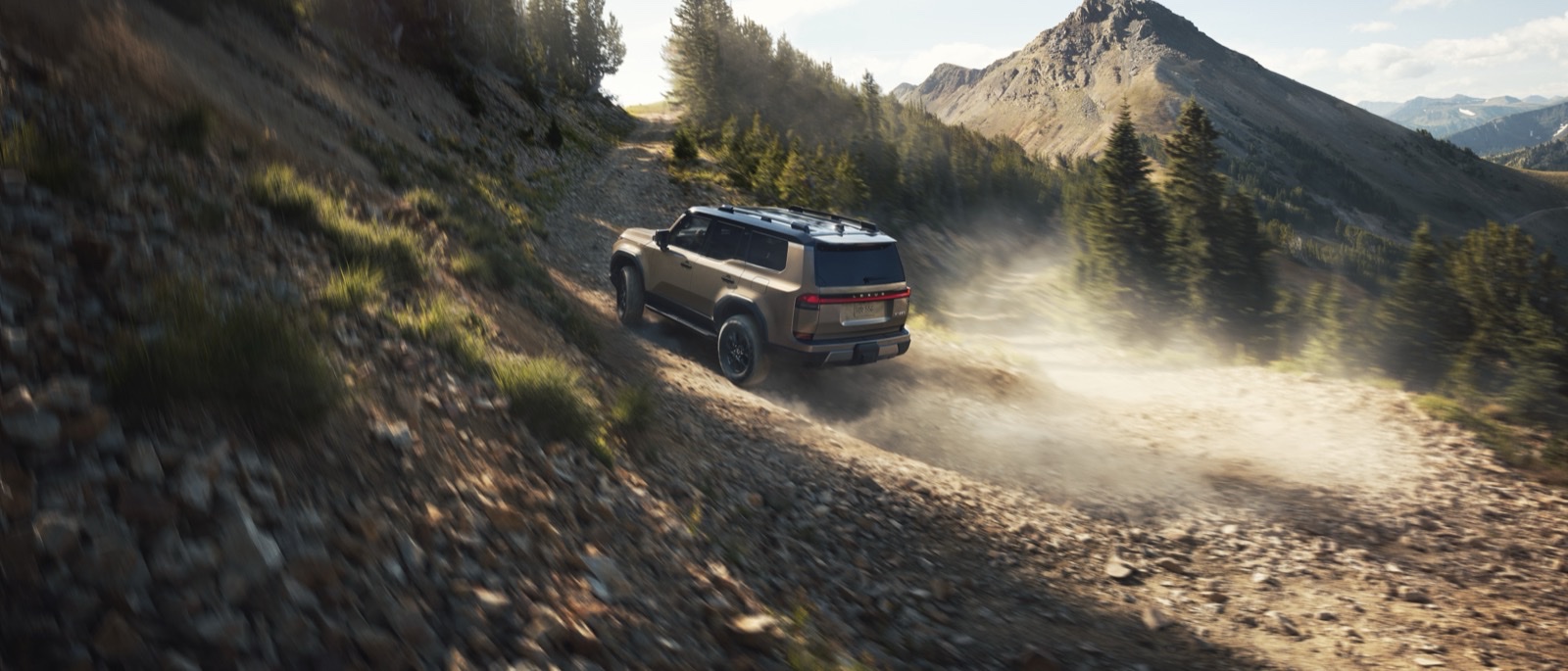 2026 Lexus GX 550 Overtrail climbing a mountain switchback at golden hour, kicking up dust