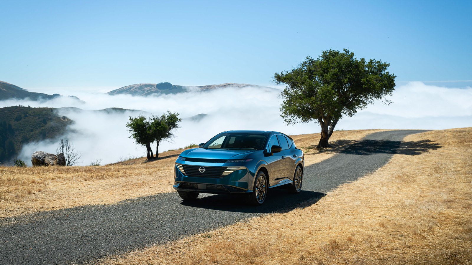 2026 Nissan Murano in deep blue on a cinematic California coastal-hills road, front three-quarter view